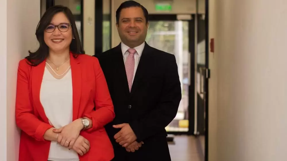 Una mujer y un hombre posando sonriendo